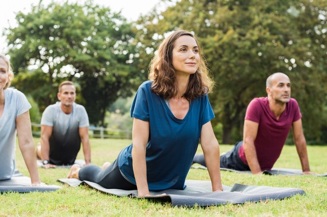 Mature healthy people doing yoga at park. Group of multiethnic p